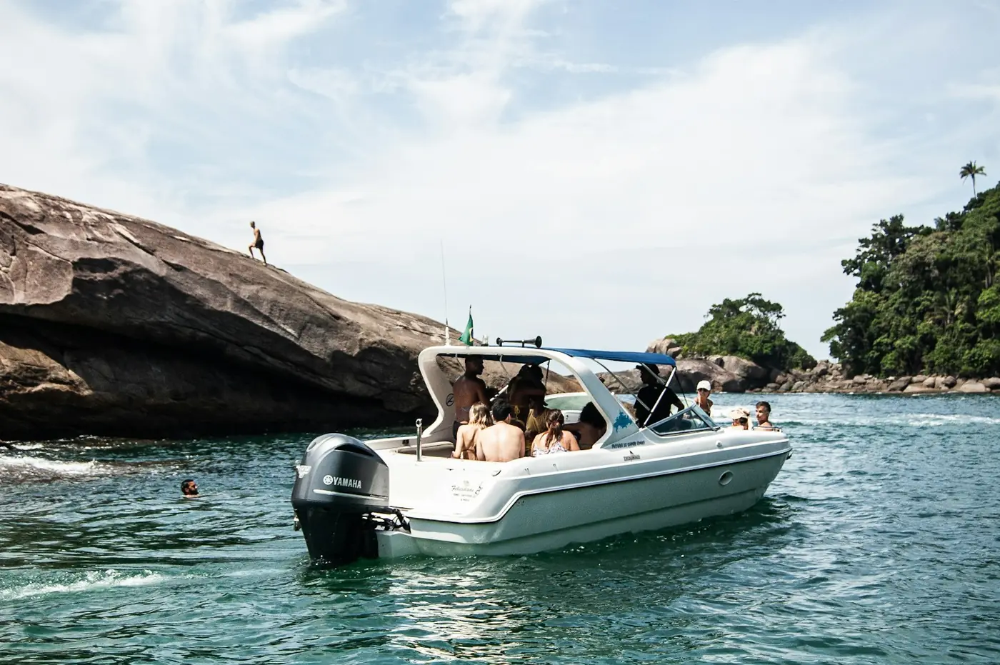 Um pequeno barco com um grupo junto às rochas