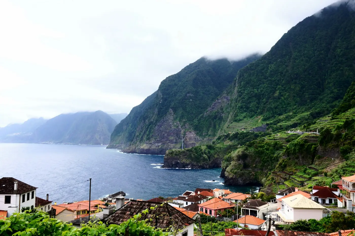A coastal village under green cliffs